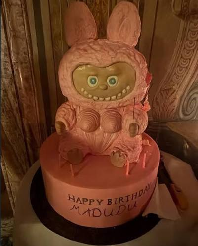 Madonna standing with her custom evil eye birthday cake